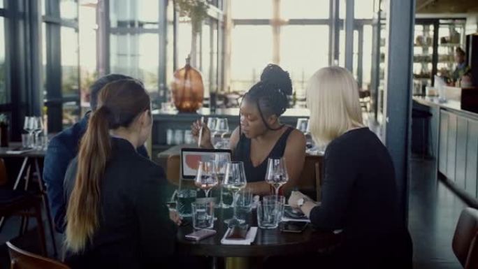 非裔美国女商人在商务午餐期间用数字平板电脑进行演讲 (慢动作)