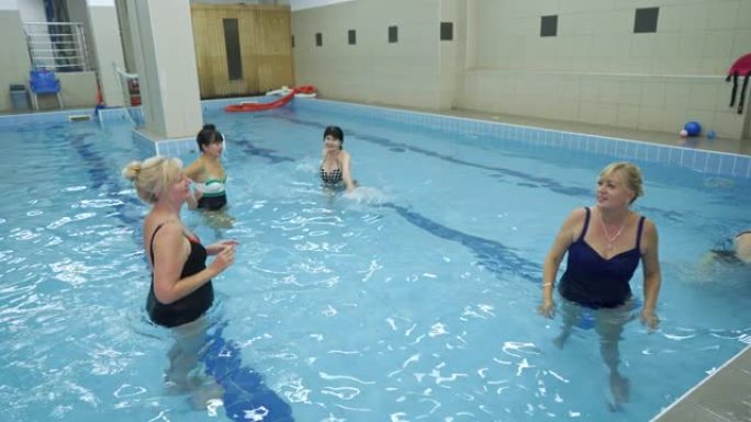 作为康复过程的一部分，重要的高级妇女在游泳池参加水上运动。