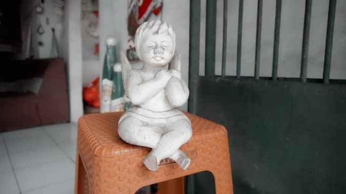木制白色彩色天使玩具坐在房子的椅子上