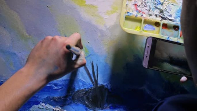 艺术家抄写员用海洋中的船绘制海景。工匠装饰师在蓝色的海上航行时画画。手机平板电脑。