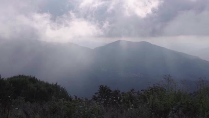 在多云的雾天，从高高的山丘上可以看到一座山。