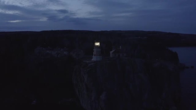 夜间点燃信标的劈开岩石灯塔的天线