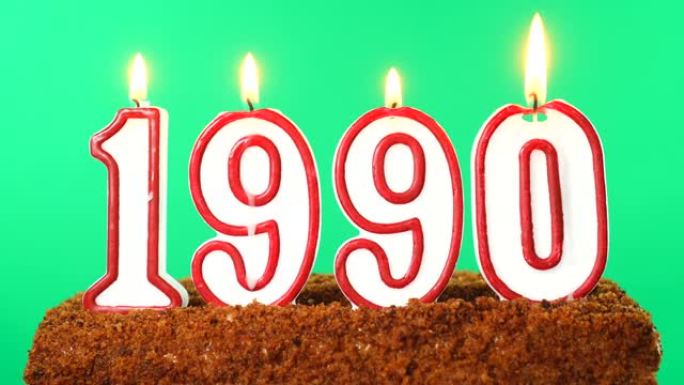 蛋糕与数字1990点燃的蜡烛。上个世纪的日期。色度键。绿屏。隔离