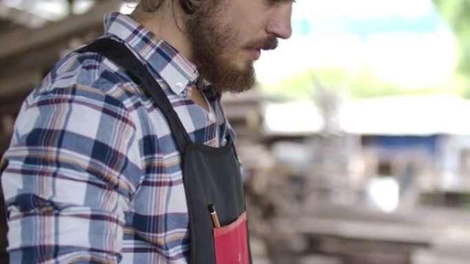 特写。胡子英俊的年轻小企业主或专业工匠或木匠木材厂准备去工业家具制造工作的肖像。创业理念。