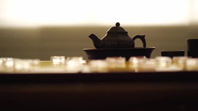 在黄金棋盘上用玻璃中国象棋向茶具倒热水