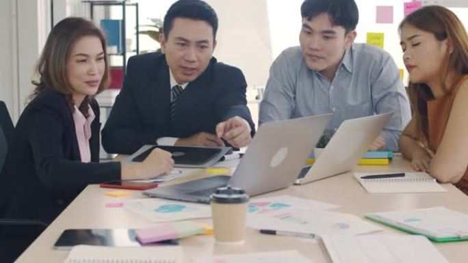 亚洲商人经理与员工会面，在现代办公室讨论项目共享想法，在会议室与同事集思广益，商务人士一起工作。