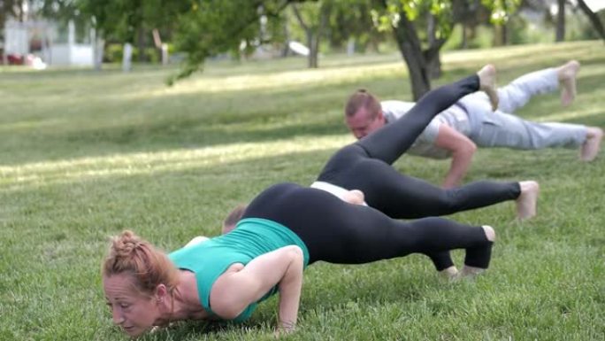 一群人在日落时在公园里做瑜伽。健康的生活方式，冥想和健康