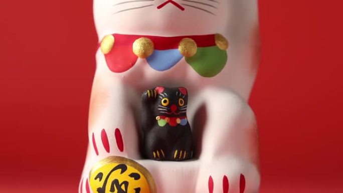 Maneki-neko，幸运的猫，有一只黑色的小猫特写