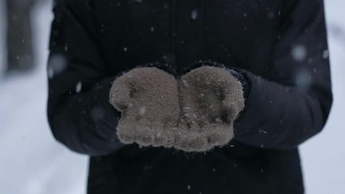 女人喜欢降雪，看着蓝色手套上的小雪花