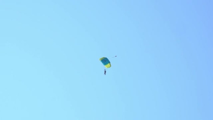 双人跳伞。在蓝色晴朗的天空中飞行的跳伞运动员的剪影