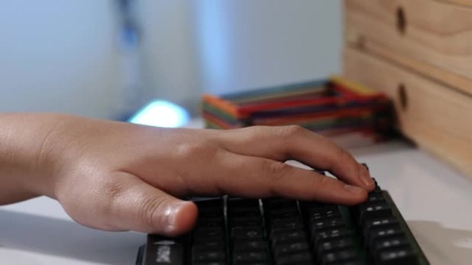 孩子的手用电脑在家玩网络游戏，生活方式概念。