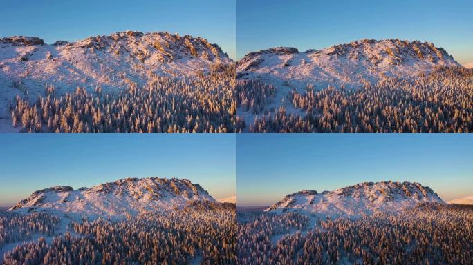 奥特克利克诺伊山脊和针叶林在冬天日落时。鸟瞰图。塔加奈国家公园，俄罗斯南部乌拉尔。无人机向后飞行