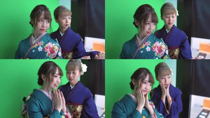 穿着 “furisode” 和服的年轻女性在 “purikura'” 照片贴纸亭为 “seijin 