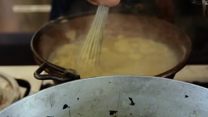 在铜质杯中搅拌和混合一种称为玉米粥的传统食品