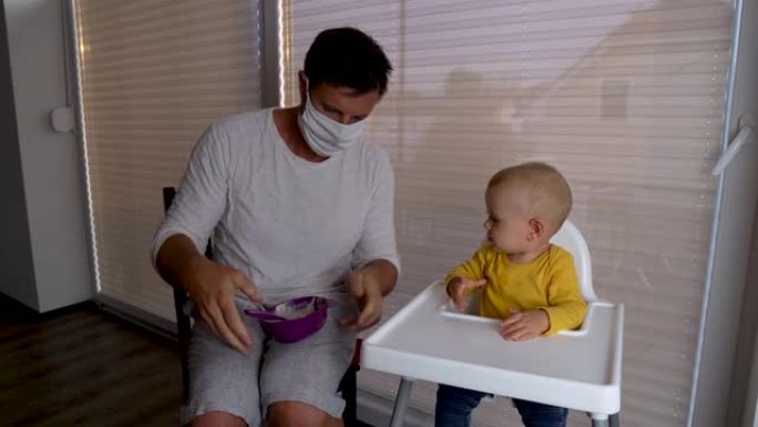 一位父亲戴着医用口罩给他的手消毒，并开始喂养他的婴儿。
