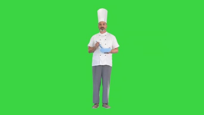 厨师用碗和鞭子在绿色屏幕上准备食物，色度键