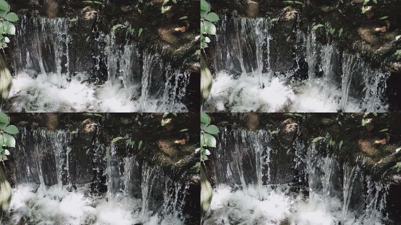 瀑布流过岩石，瀑布在岩石上，小溪特写。
