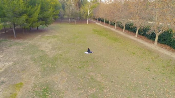 躺在奥托纳尔草地上的黑衣人女子鸟瞰图无人机