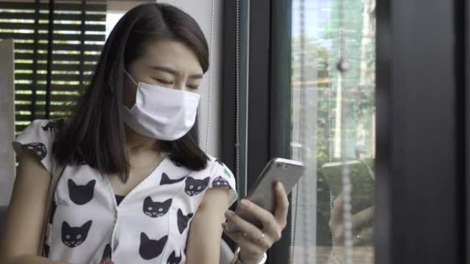 年轻的亚洲女性戴着防护面具，在咖啡馆使用智能，新常态