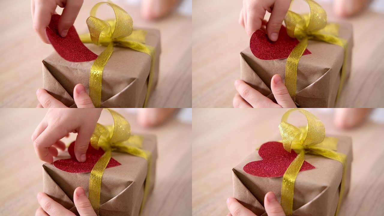 小男孩正准备给他心爱的女孩情人节礼物。儿童装饰大红心礼品盒。慢动作