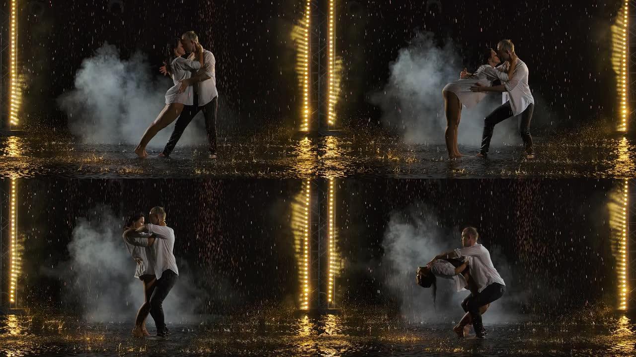 热情的湿夫妇在雨中亲吻和跳舞。雨滴中的爱情故事。在带有舞台灯光的烟熏黑色工作室背景下以慢动作拍摄