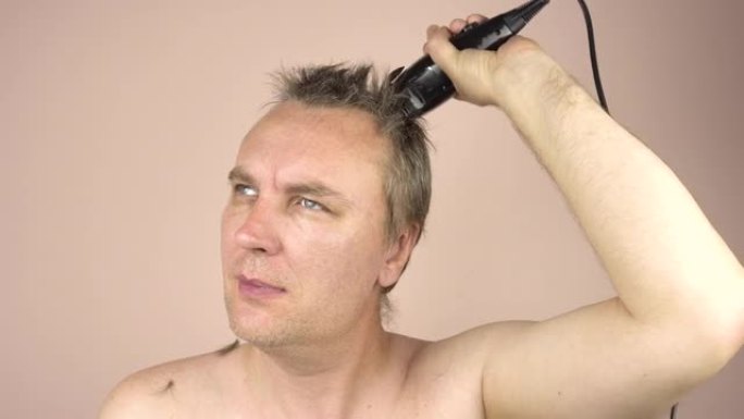 一个金发的成年男子用剪子理发。