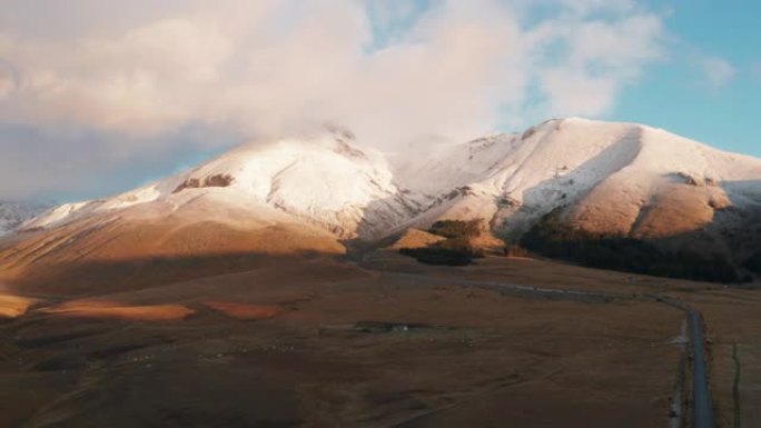 在坎波的黎明，背景是一群牛和下雪的山脉