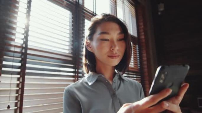 美丽的亚洲女人使用智能手机