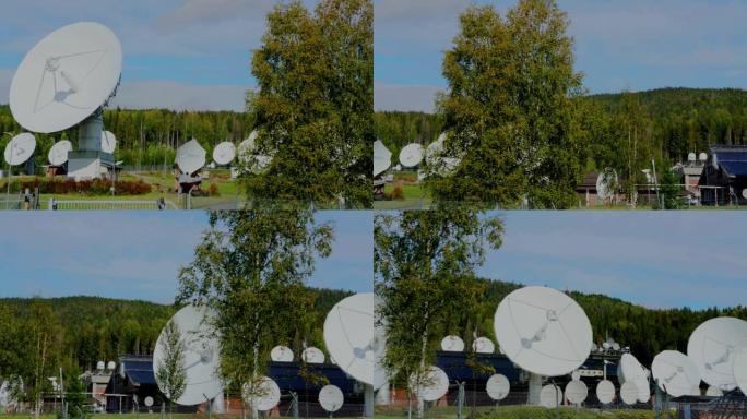 大型白色无线电雷达光盘，背景为蓝天和树木。