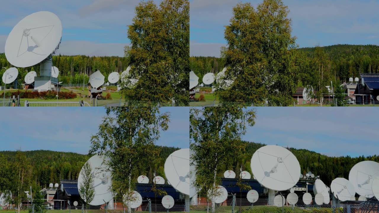 大型白色无线电雷达光盘，背景为蓝天和树木。