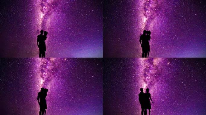 一对夫妇在带有流星的紫色银河系前亲吻和拥抱的剪影
