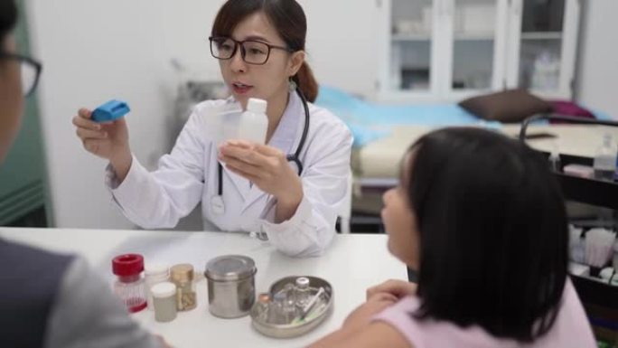 亚洲华裔女医生开药并向患者父亲解释。