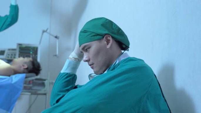悲伤的外科医生坐在医院走廊的地板上