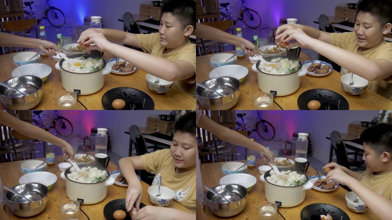快乐的亚洲男孩和他的妹妹在家里一起用寿喜烧或sha锅做饭，生活方式概念。