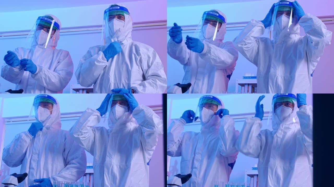一组在实验室佩戴个人防护装备 (PPE) 的科学家。