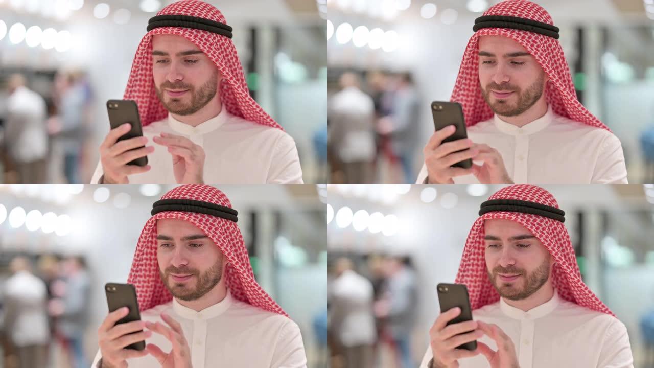 使用智能手机的严肃的阿拉伯商人肖像