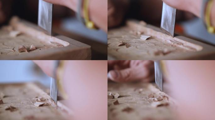 宏观。木雕师制作一个木托盘。工匠用平冲击凿子加工胡桃板
