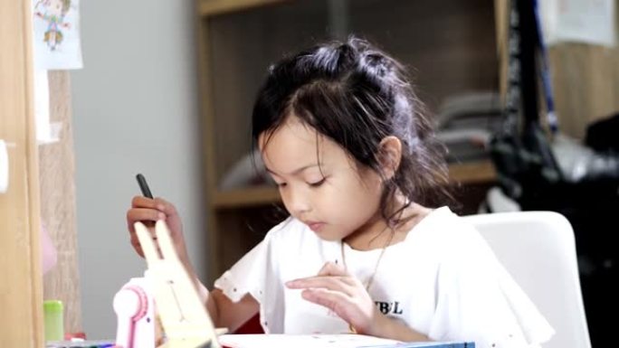 亚洲女孩在家做作业，在家上学的概念。