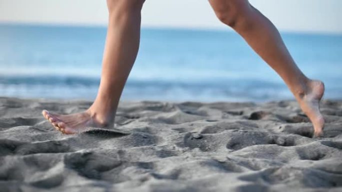 光脚女人的腿在沙滩上跑步，花时间在海边附近。4k Dragon RED摄像机