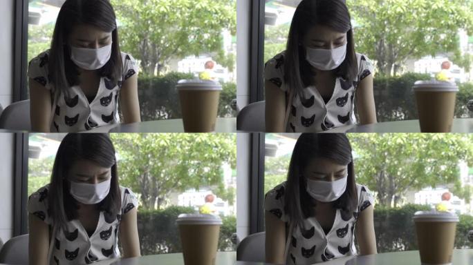 年轻的亚洲女性戴着防护面具，在咖啡馆使用智能，新常态