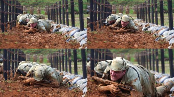 士兵们正在训练用步枪在泥泞中爬行。