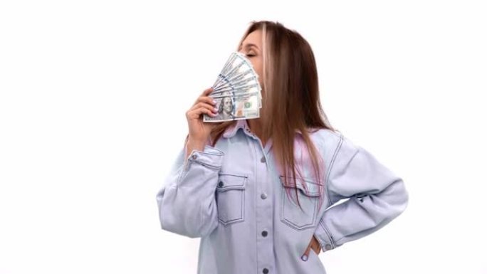 大喜过望的女子享受着现金的气味，吹着孤立的钱扇摆姿势。4k Dragon RED摄像机