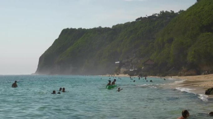 巴厘岛著名的melasti海滩拥挤的海岸线慢动作全景4k印度尼西亚