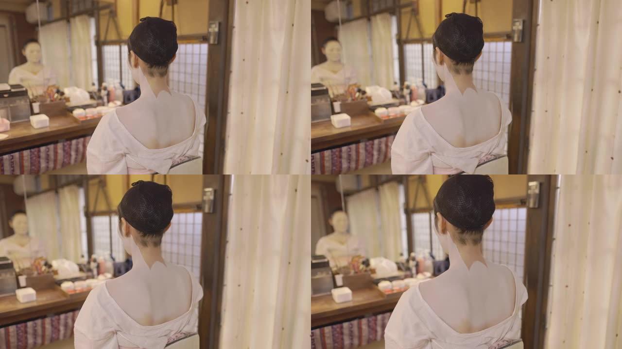 穿着 “oshiroi” 特殊白色妆容的日本女人坐在试衣间