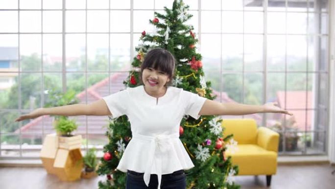 聋哑女孩使用手势欢迎圣诞树背景