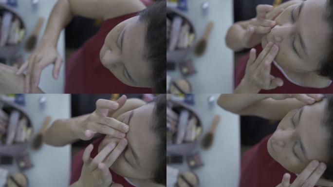 亚洲女性在化妆前先在脸上涂抹粉底