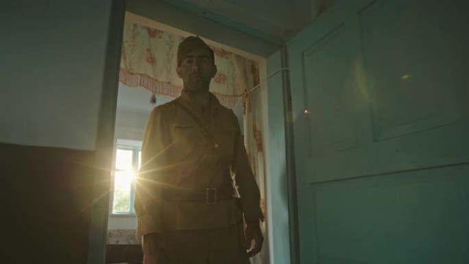 一个二战时期红军的士兵，穿着制服，站在一间旧农舍的门口，忧伤地盯着镜头。明亮的阳光从窗户照进来