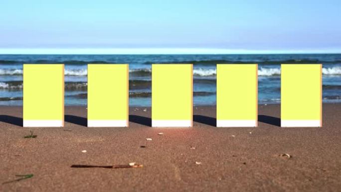 黄色和白色的纸质书籍屹立在沙滩上