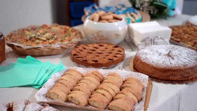 各种美味的烘焙蛋糕和饼干，配有不同的水果配料和装饰品，在宴会桌上准备庆祝活动。邀请客人的甜点桌，蛋糕