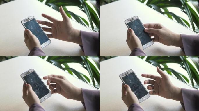 女人手里拿着破智能手机。